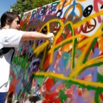 Una joven pinta un grafitti durante un acto festivo en Barcelona