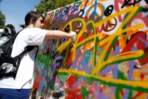 Una joven pinta un grafitti durante un acto festivo en Barcelona