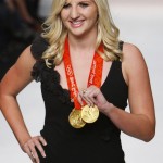 British swimming gold medallist Rebecca Adlington holds her medals as she models a dress during Naom